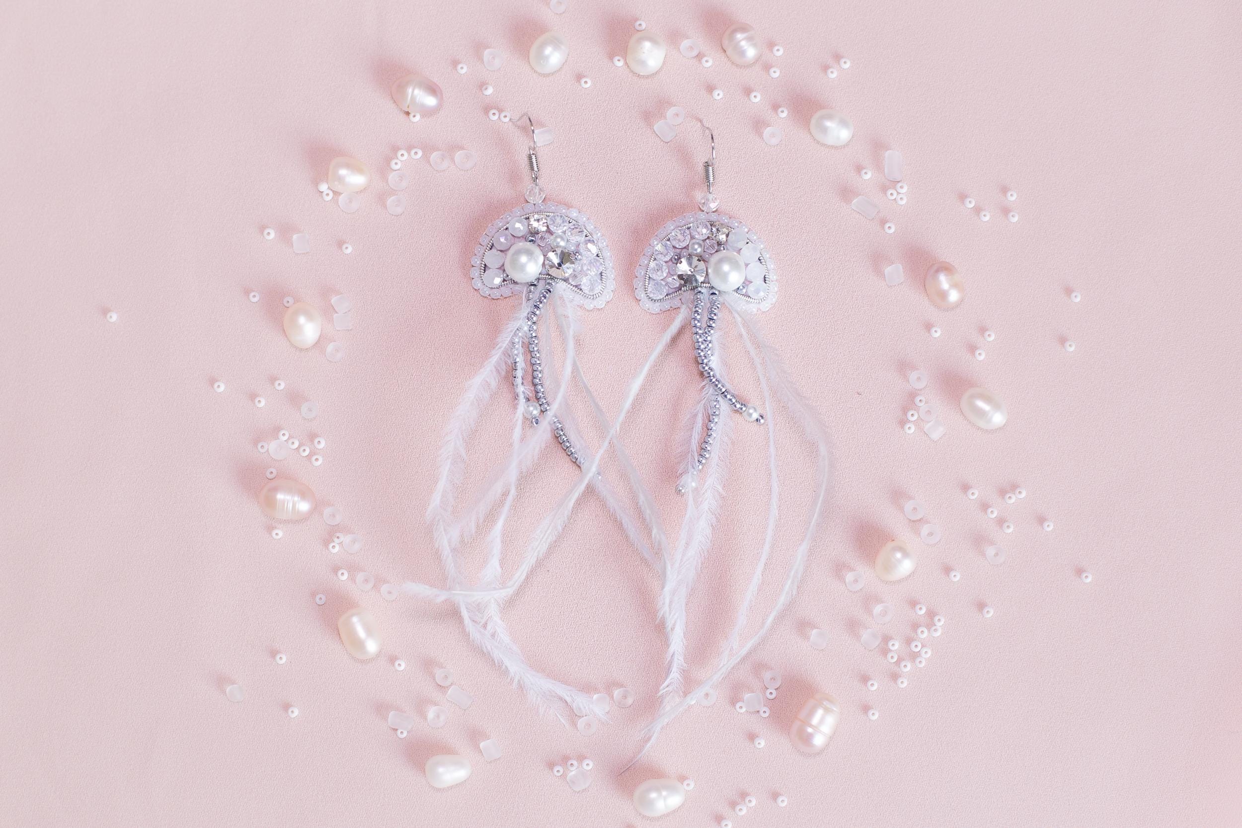 a pair of white bowknots with pearls on a pink background
