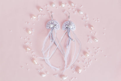 a pair of white bowknots with pearls on a pink background