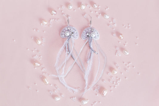 a pair of white bowknots with pearls on a pink background
