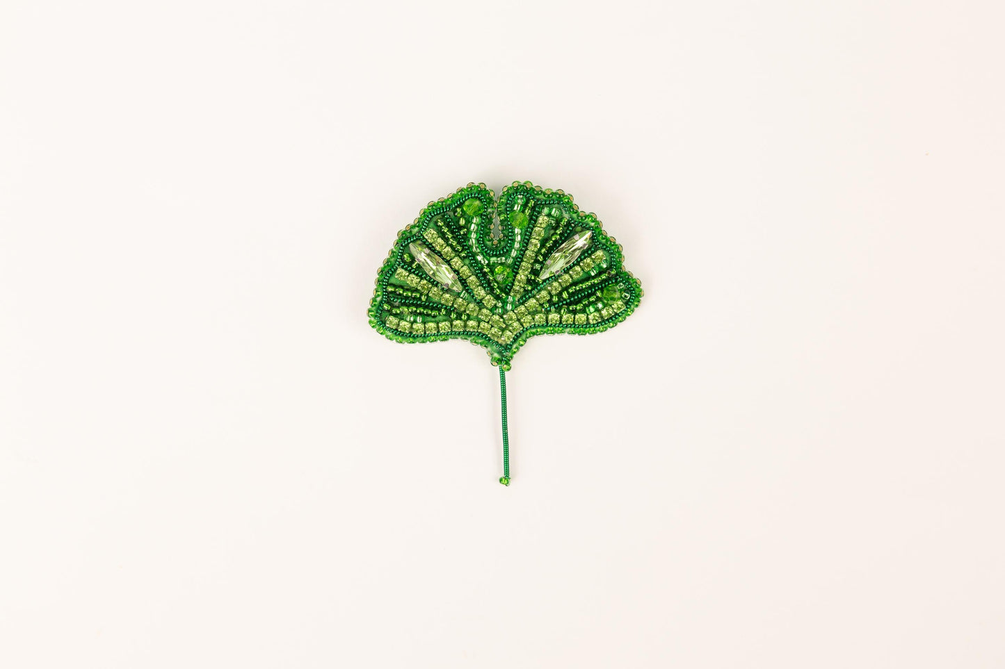 a green beaded leaf on a white background