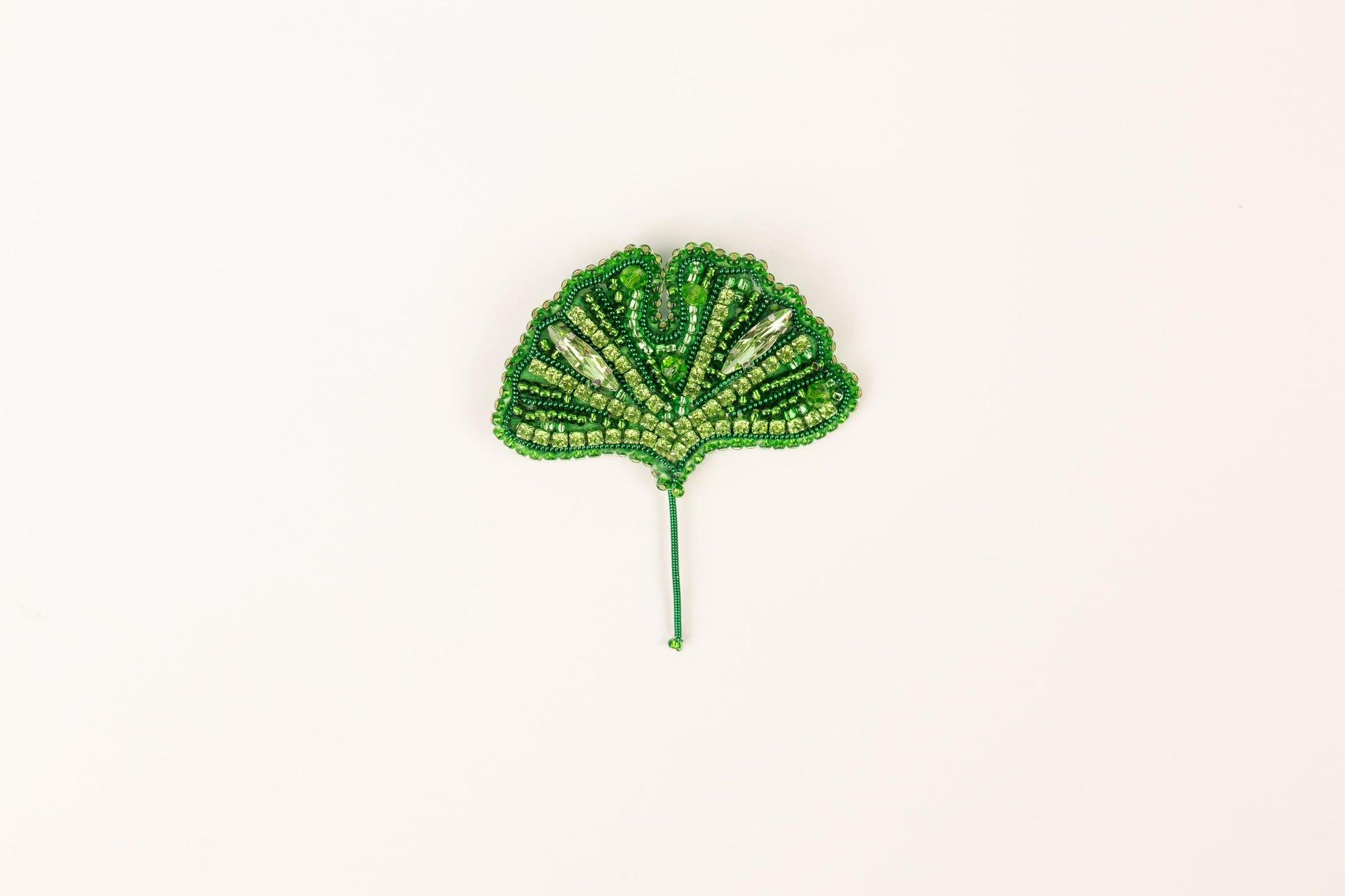 a green beaded leaf on a white background