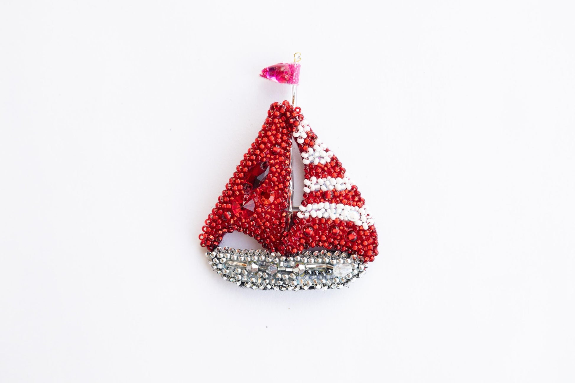 a red and white beaded sailboat ornament