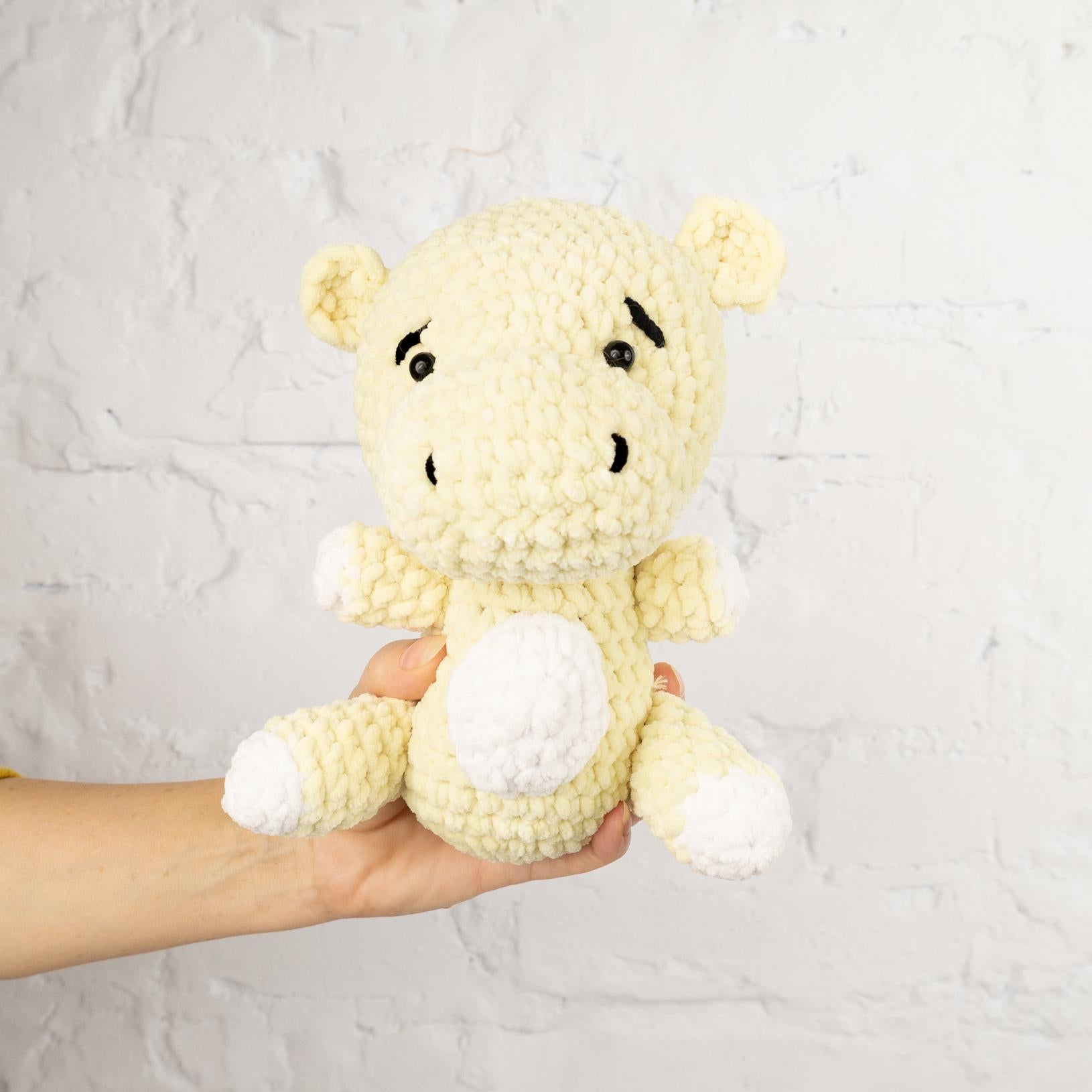 a person holding a small stuffed animal in their hand