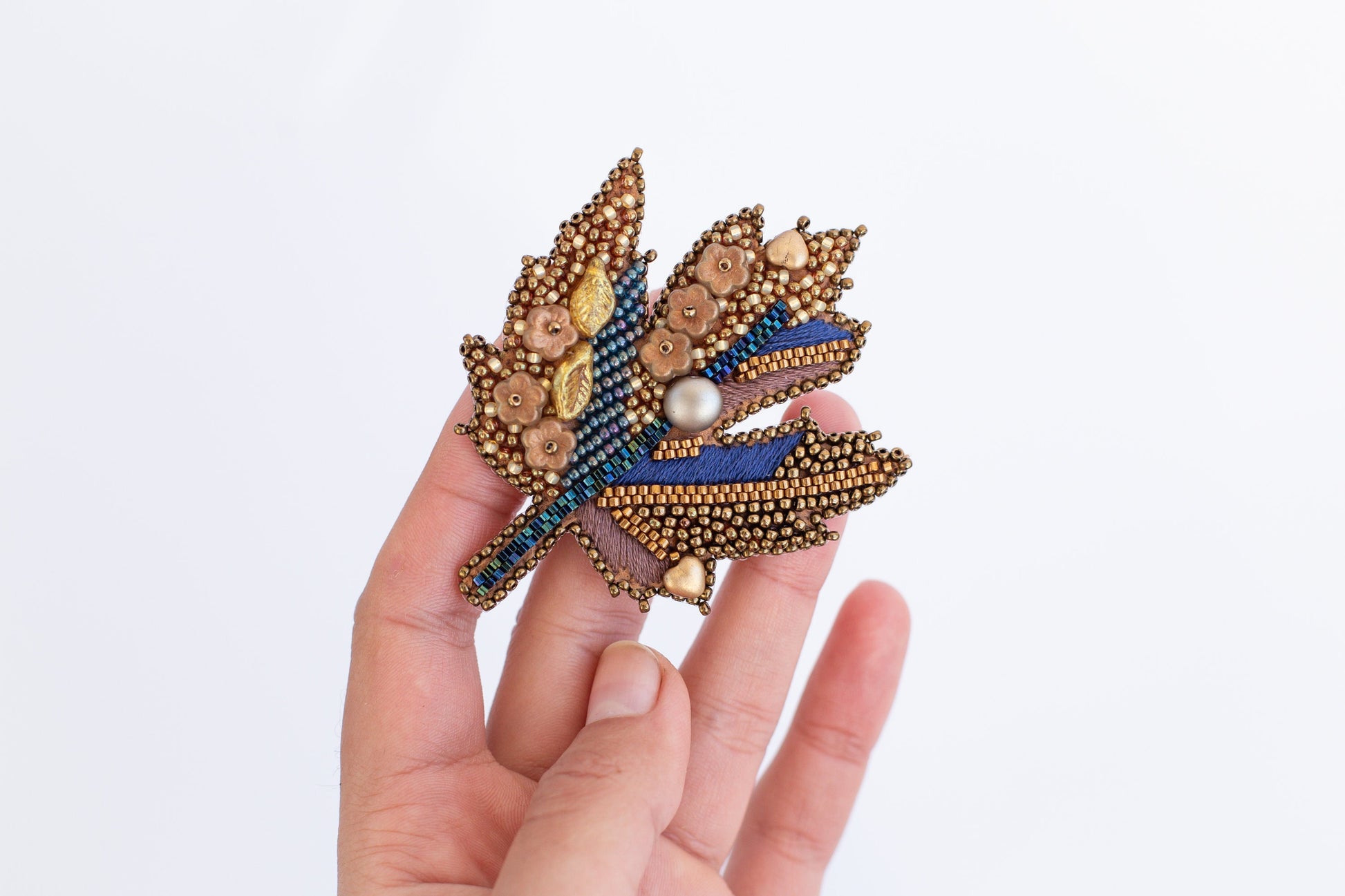 a person is holding a brooch in their hand