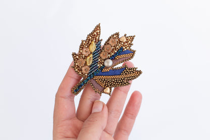 a person is holding a brooch in their hand