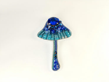 a brooch with a blue beaded design on it