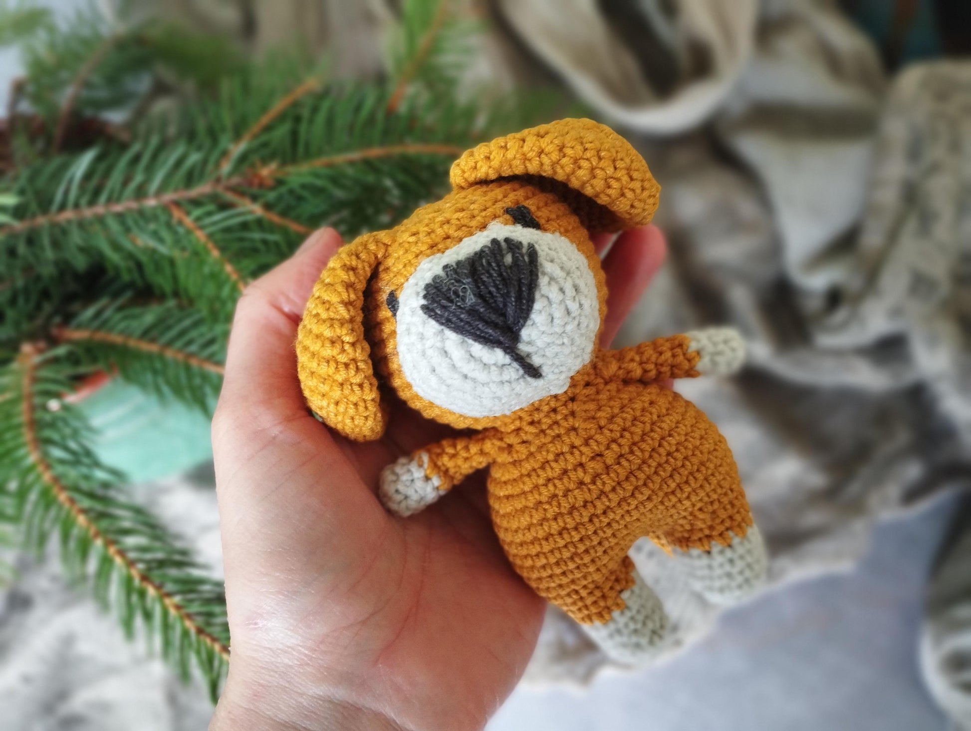 a hand holding a small crocheted stuffed animal