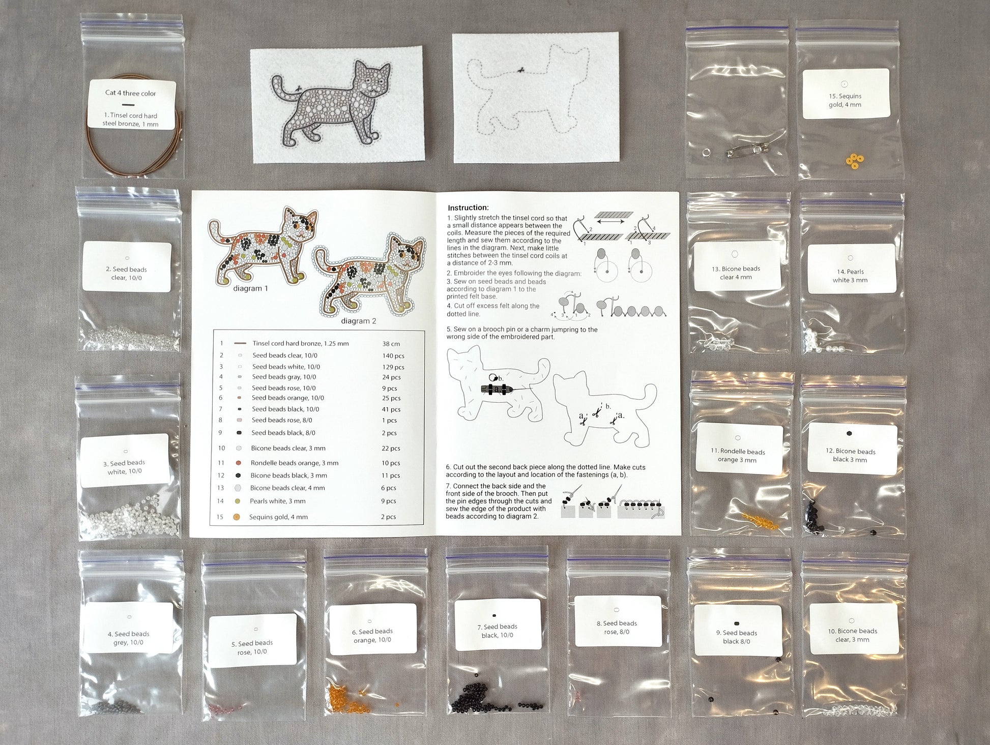 various craft supplies, including bags of beads, seeds, and instructions for a project involving cat-shaped designs.