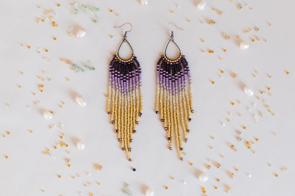 a pair of purple and yellow beaded earrings