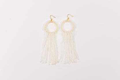 a pair of earrings with tassels hanging from them