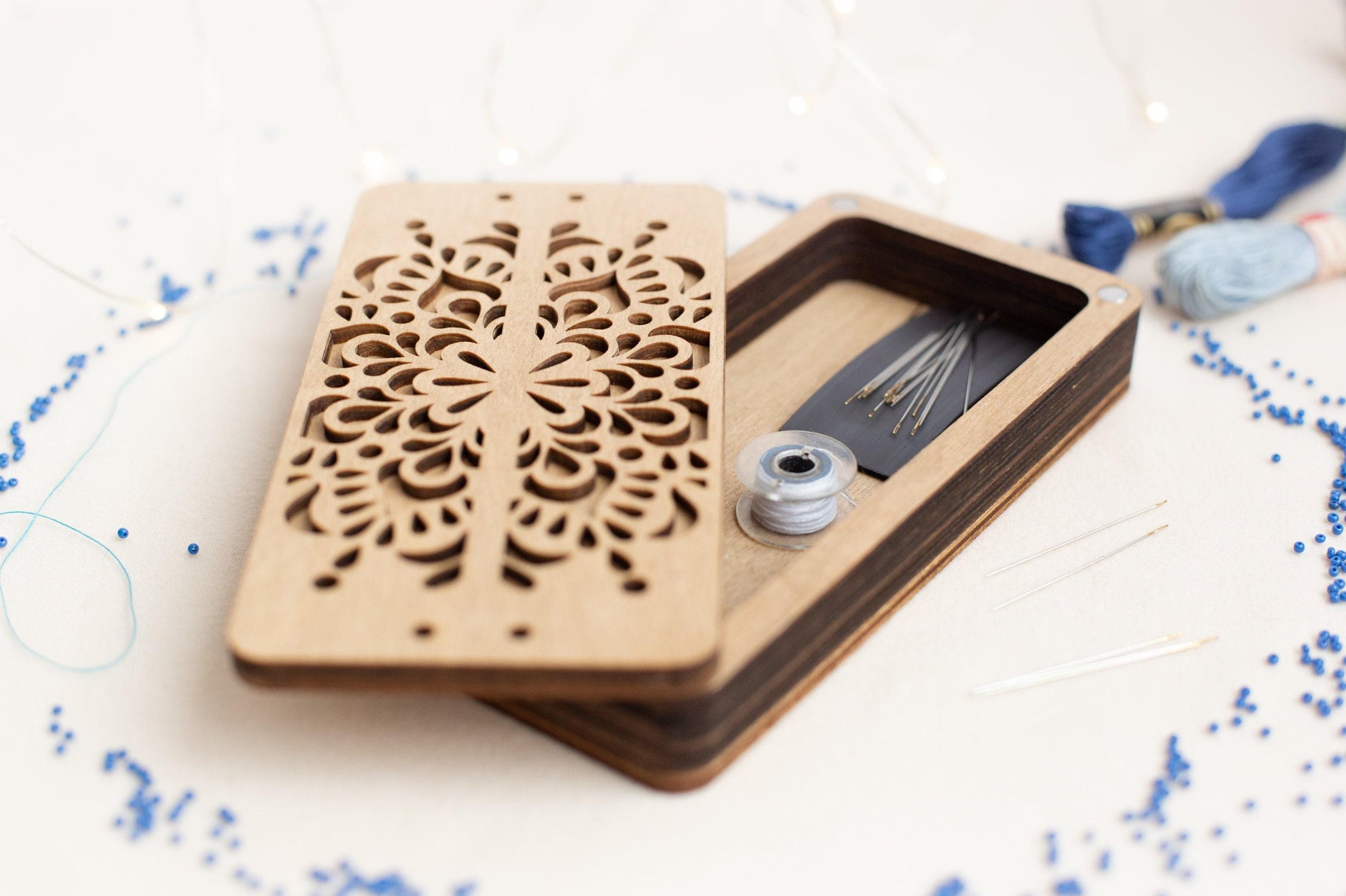 a pair of scissors and thread in a wooden box