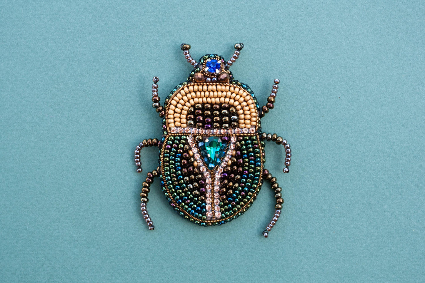 a beaded beetle sitting on top of a blue surface