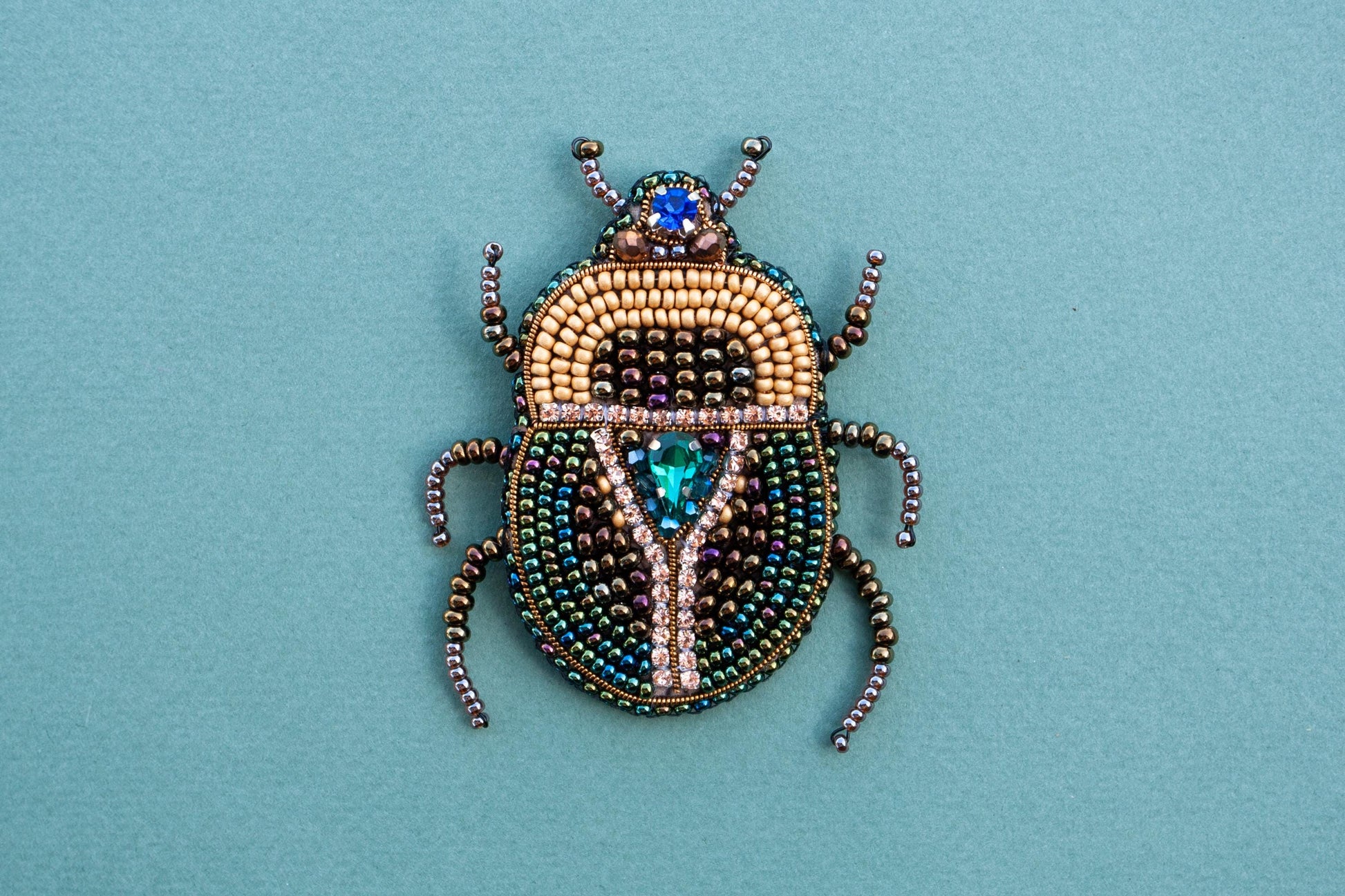 a beaded beetle sitting on top of a blue surface