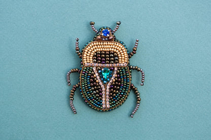 a beaded beetle sitting on top of a blue surface