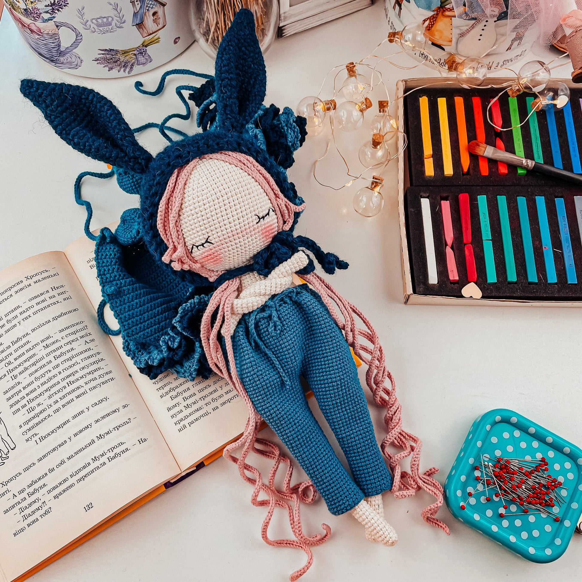 a stuffed animal sitting on top of a table next to an open book