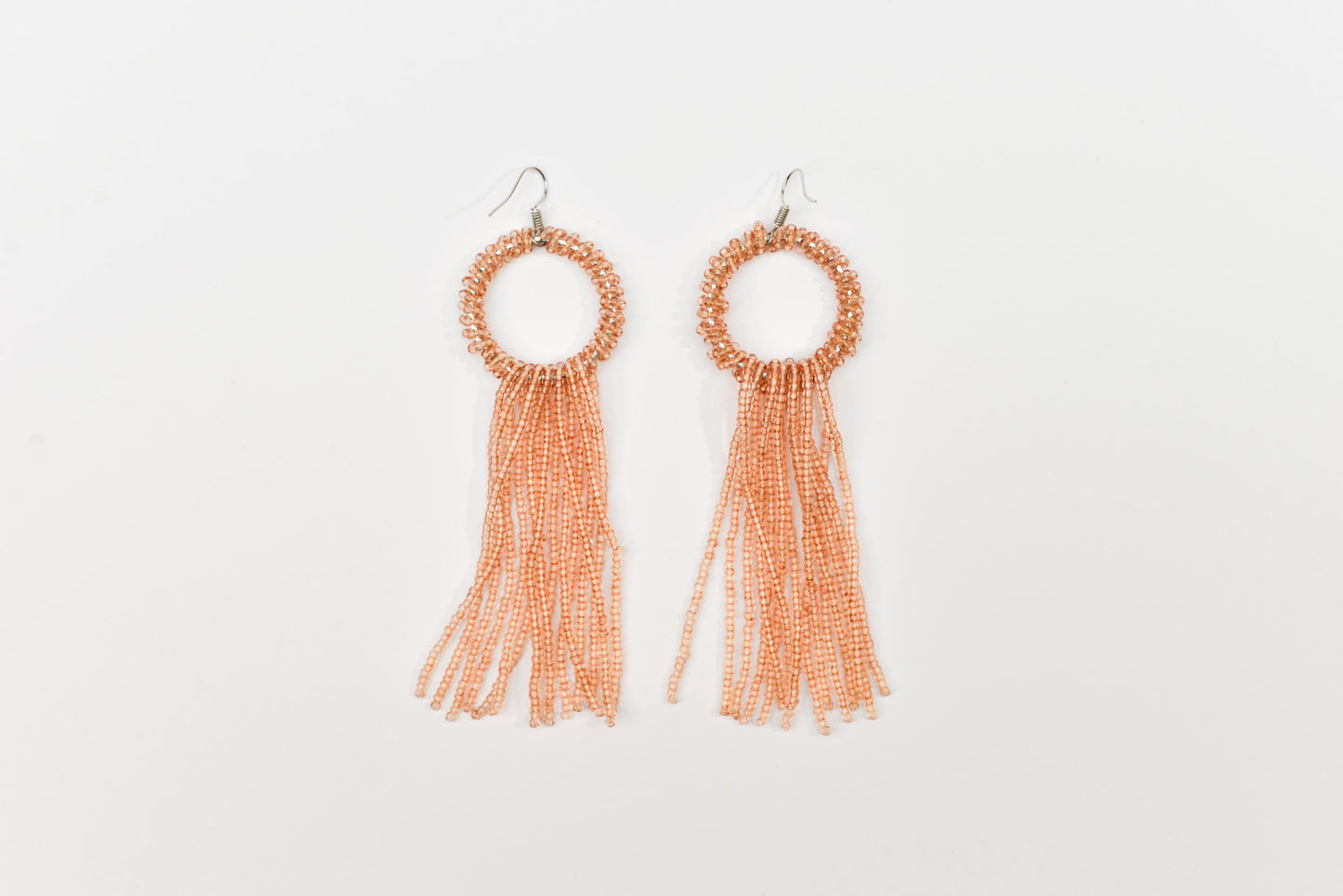 a pair of earrings with tassels on a white background