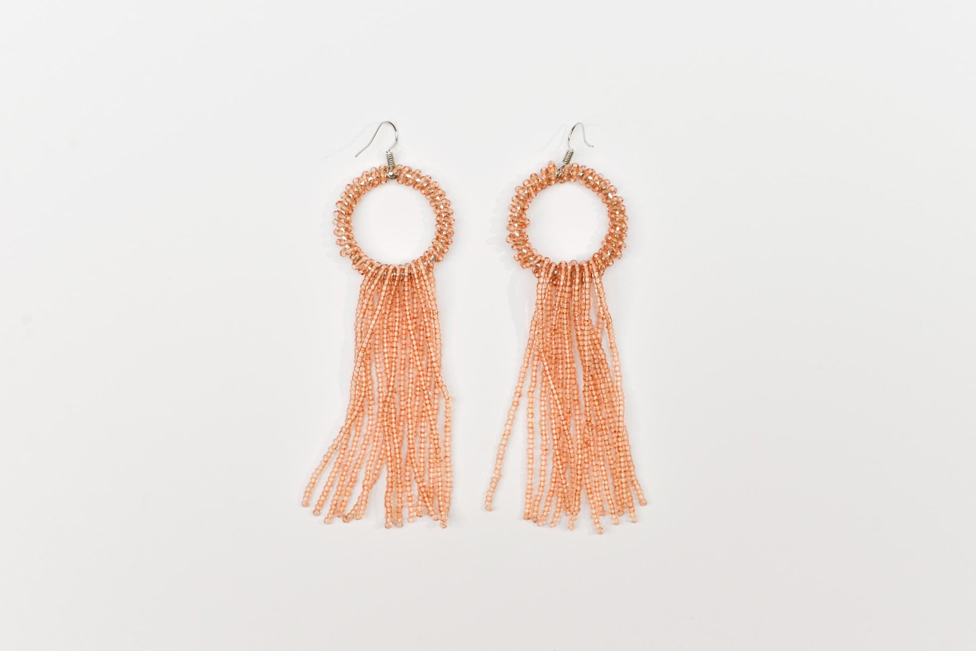 a pair of earrings with tassels on a white background