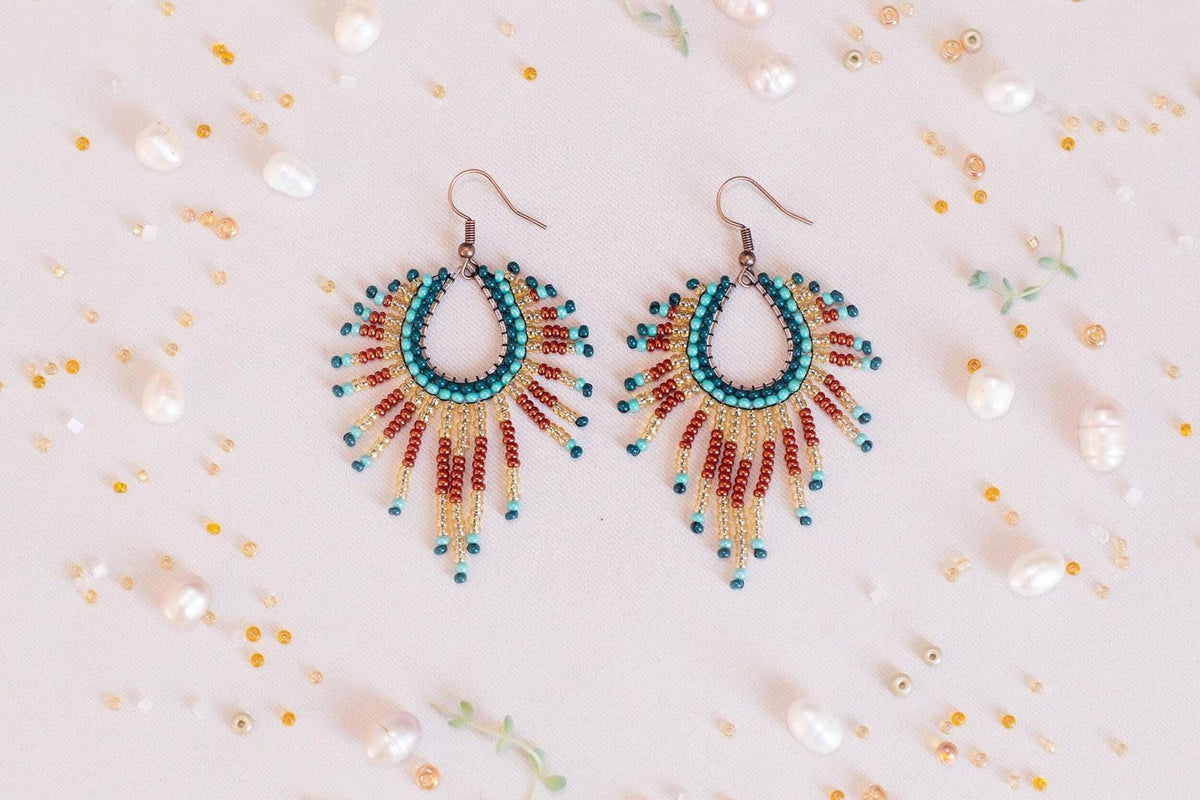 a pair of colorful beaded earrings sitting on top of a table