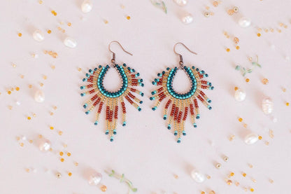 a pair of colorful beaded earrings sitting on top of a table
