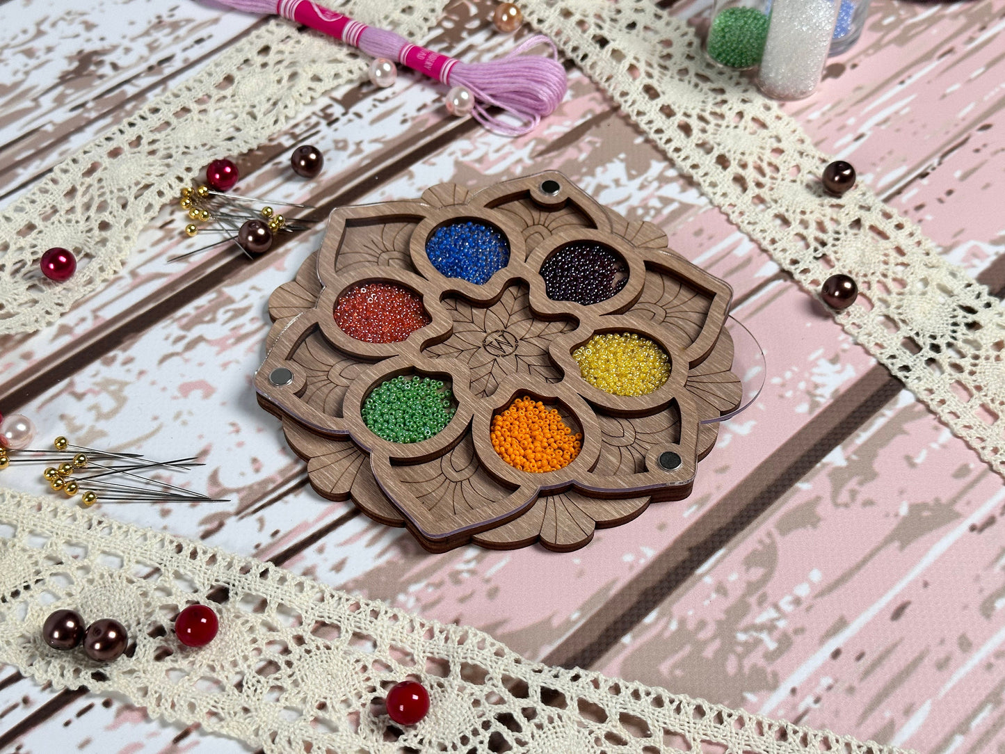 a wooden tray with a bunch of beads on top of it