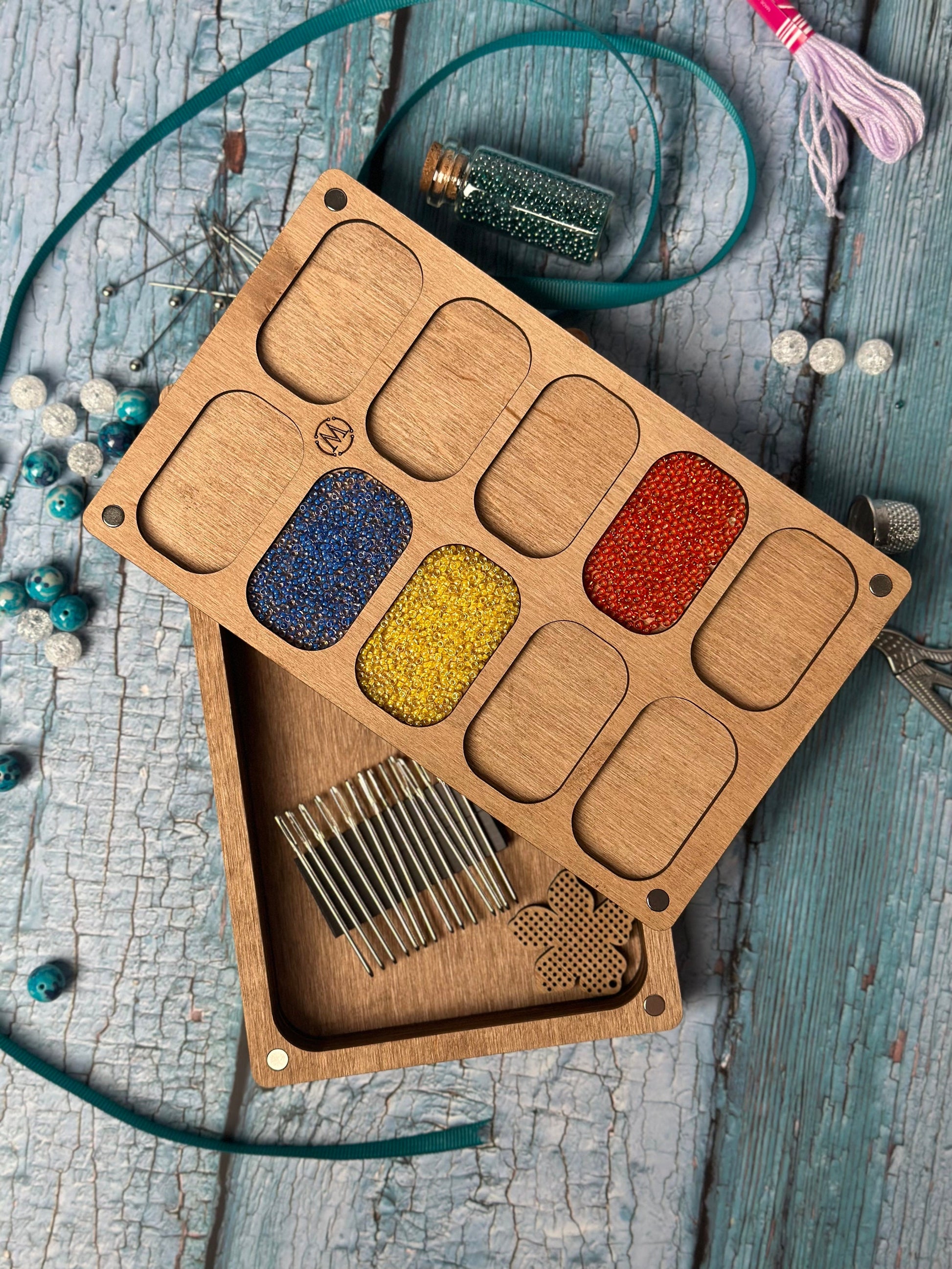 a wooden box filled with lots of different colored beads