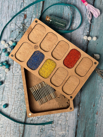a wooden box filled with lots of different colored beads