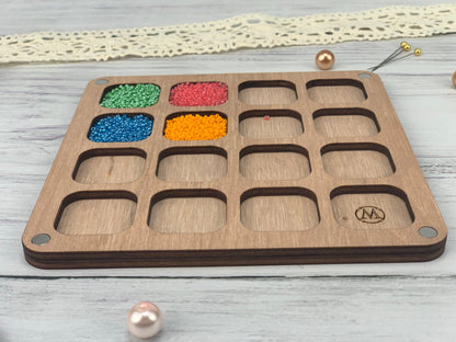 a wooden tray with beads and beads in it