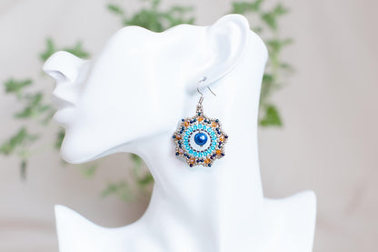 a white mannequin head with a pair of earrings on it