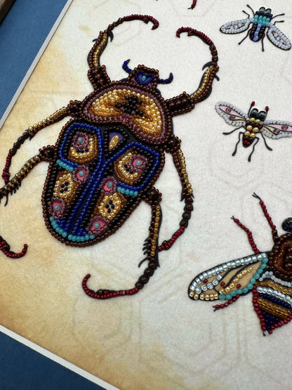 a close up of a piece of art with a bug on it