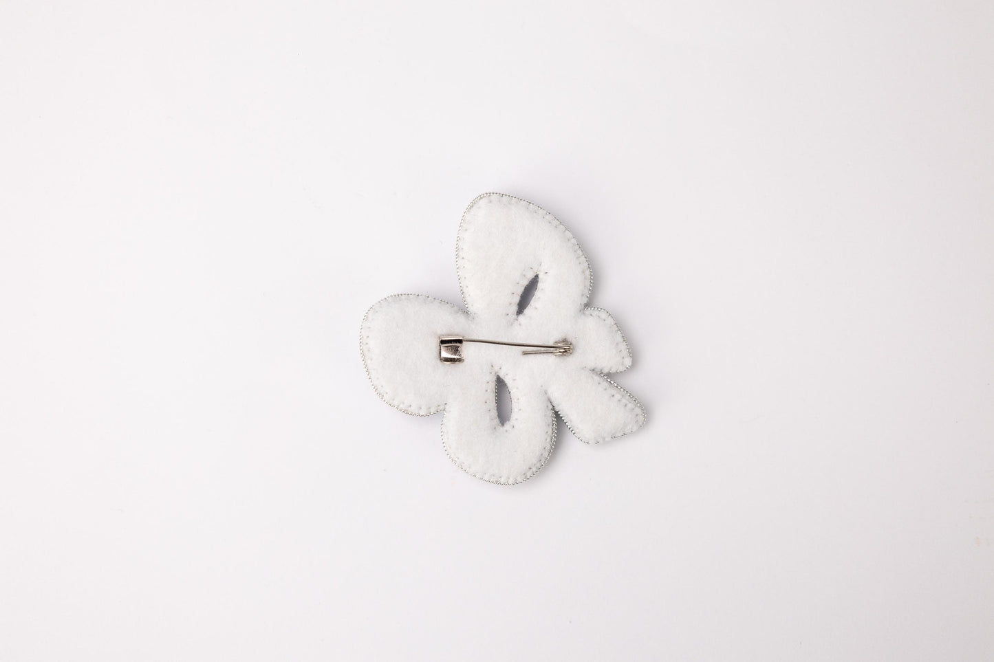 a white brooch with a white flower on it
