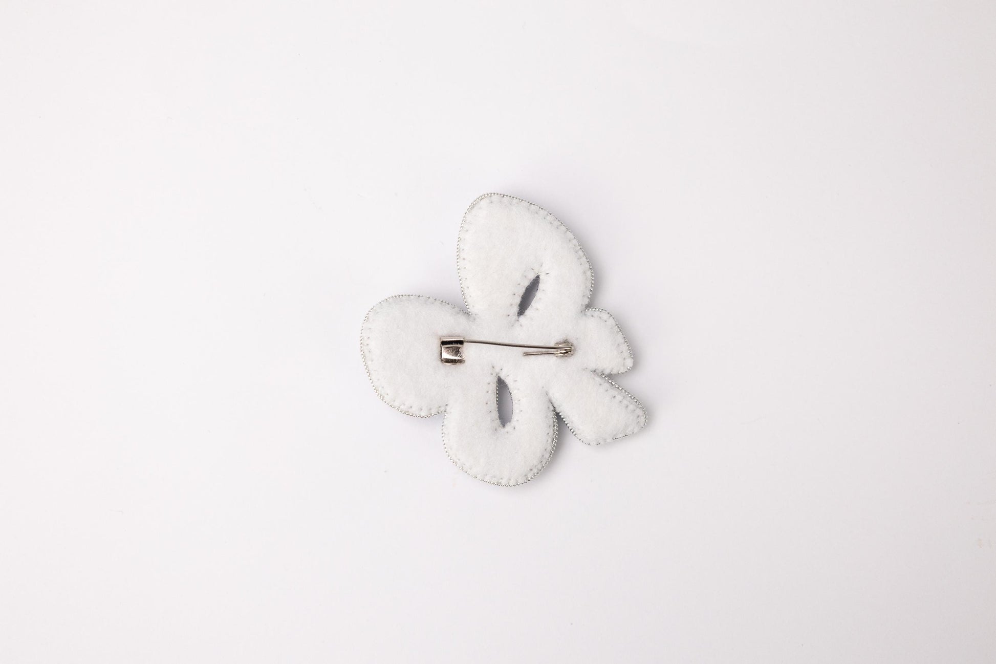 a white brooch with a white flower on it