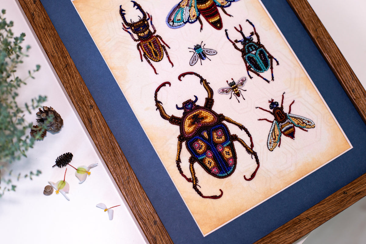 a framed artwork depicting a variety of colorful insects, including a large beetle and several smaller insects, all intricately detailed and vibrant.