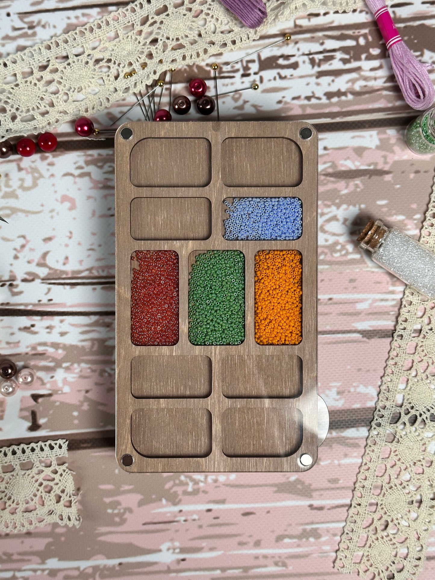 a wooden tray with different colors of beads