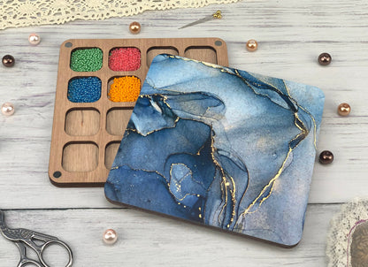 a wooden tray with a painting on it next to a pair of scissors