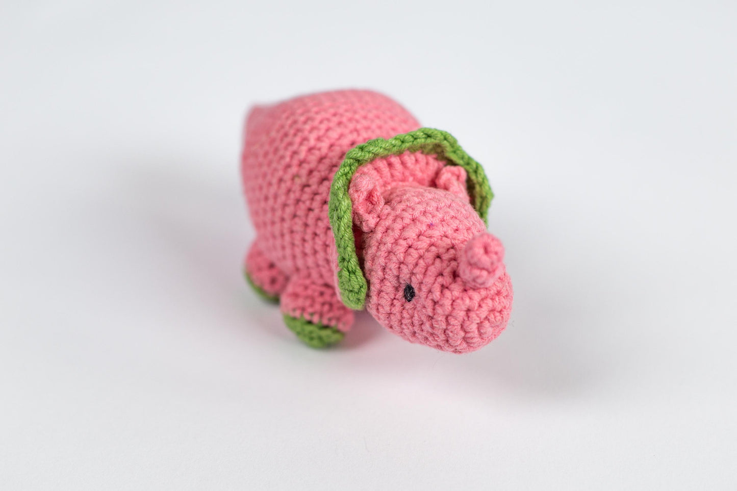a crocheted pink dog with a green collar