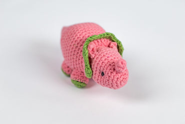 a crocheted pink dog with a green collar