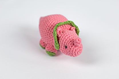 a crocheted pink dog with a green collar