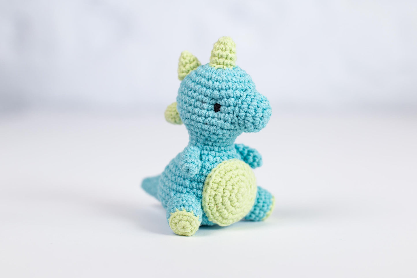 a small crocheted blue and green stuffed animal