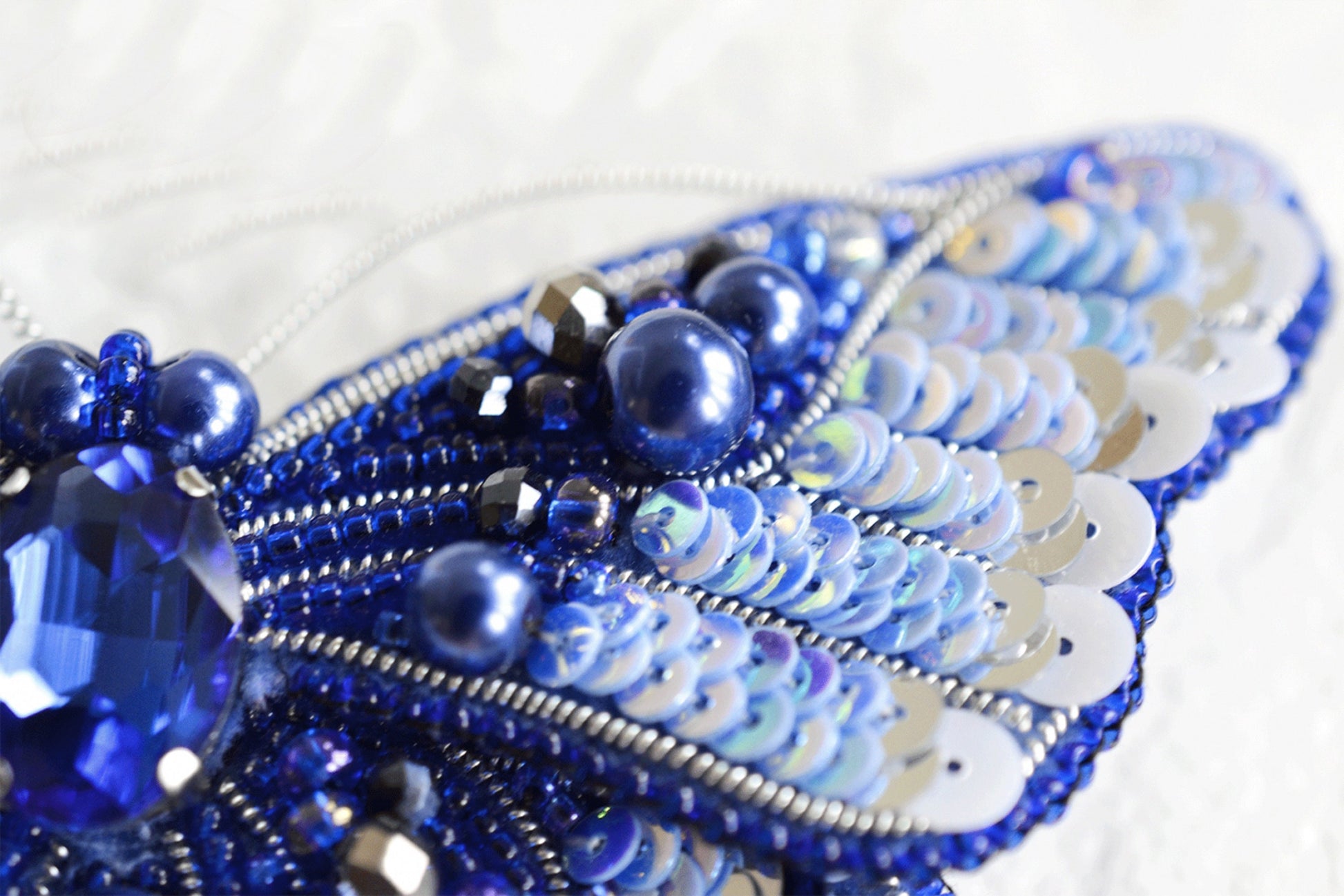 a close up of a blue beaded brooch