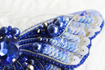a close up of a blue beaded brooch