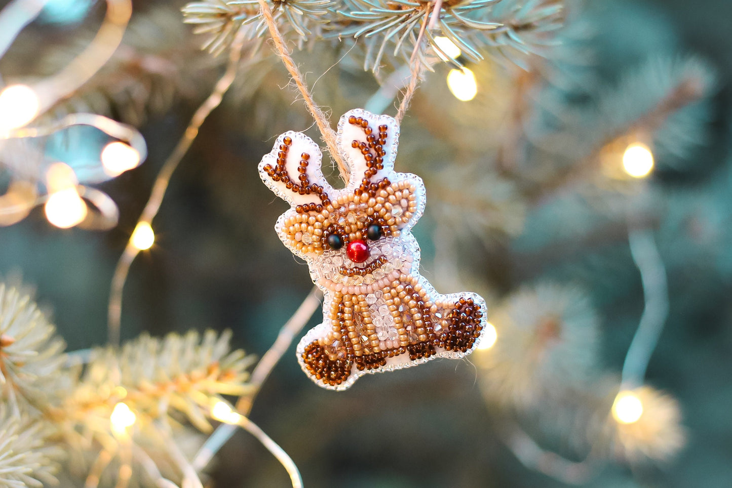 a beaded ornament hanging from a christmas tree