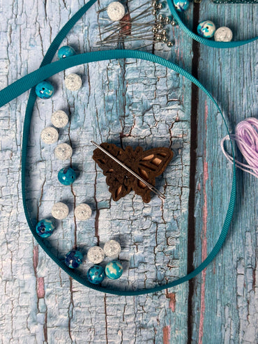 a piece of wood with a string and some beads on it