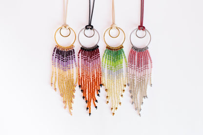 a collection of colorful beaded earrings with tassels hanging from them.