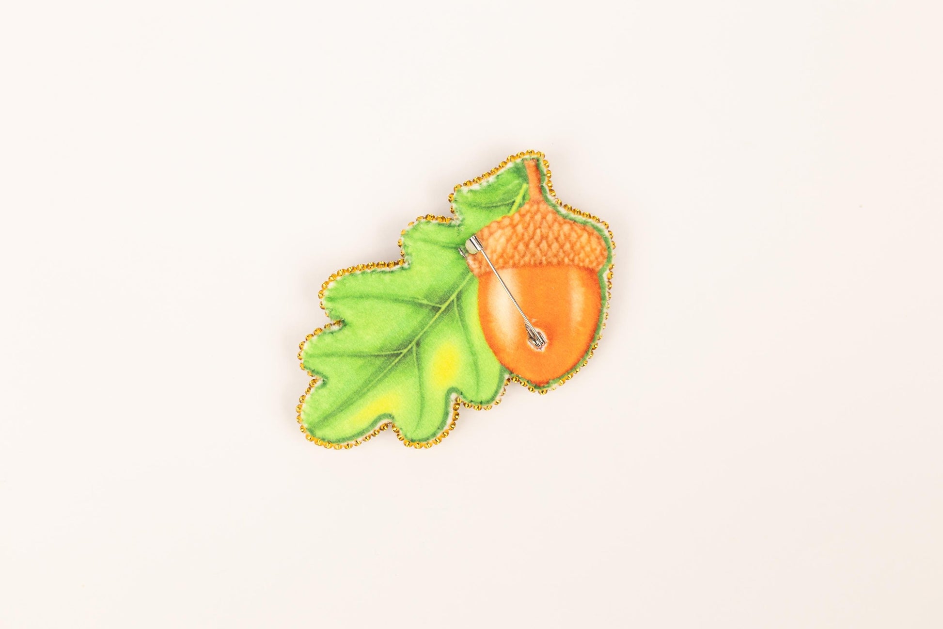 a picture of a leaf and a acorn on a white background