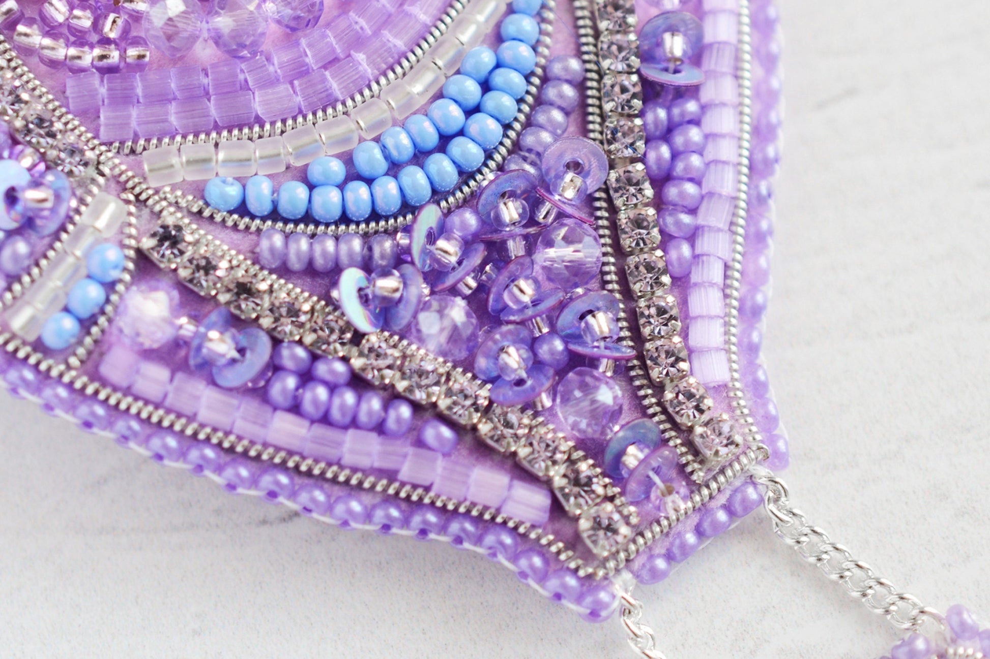 a close up of a purple and blue beaded purse