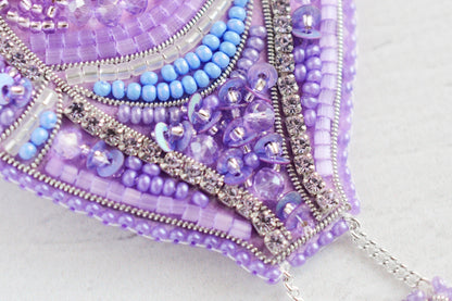 a close up of a purple and blue beaded purse