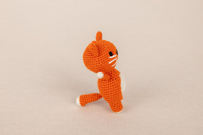 a crocheted orange cat sitting on its hind legs