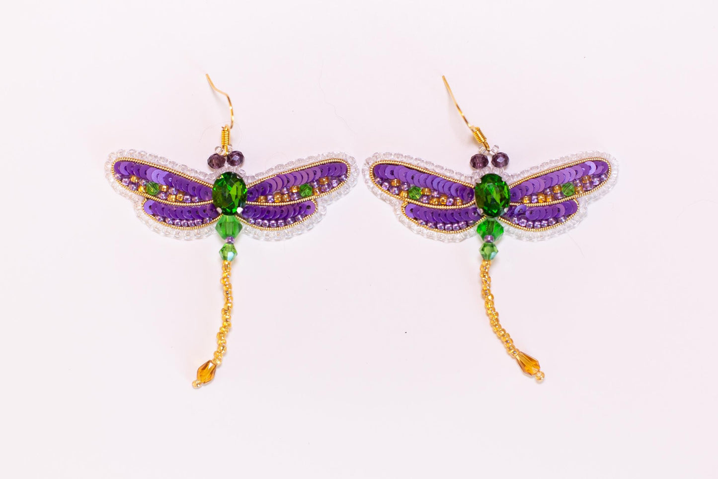 a pair of purple and green dragonfly earrings