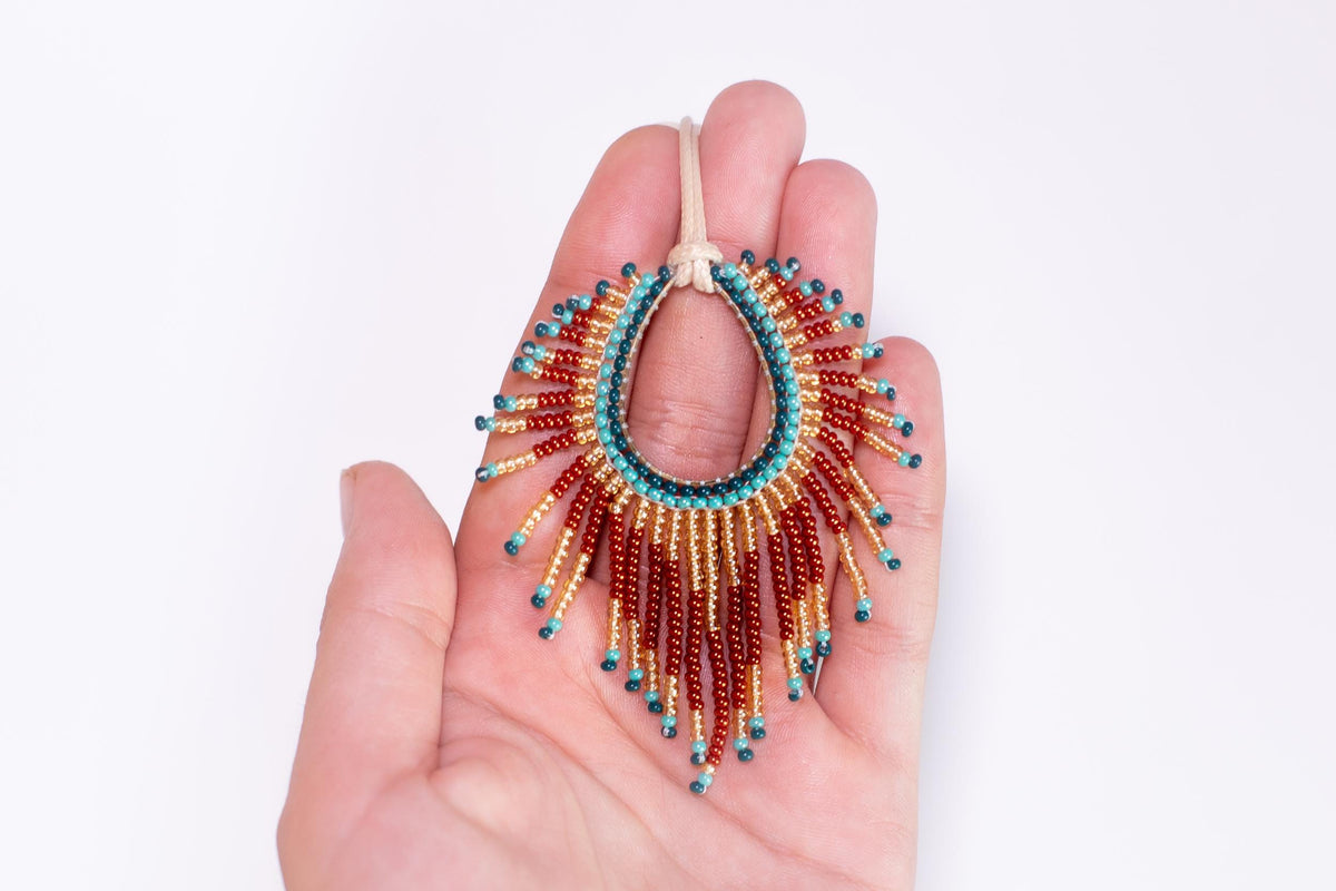 a hand holding a beaded necklace in it's palm