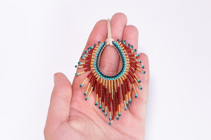 a hand holding a beaded necklace in it's palm